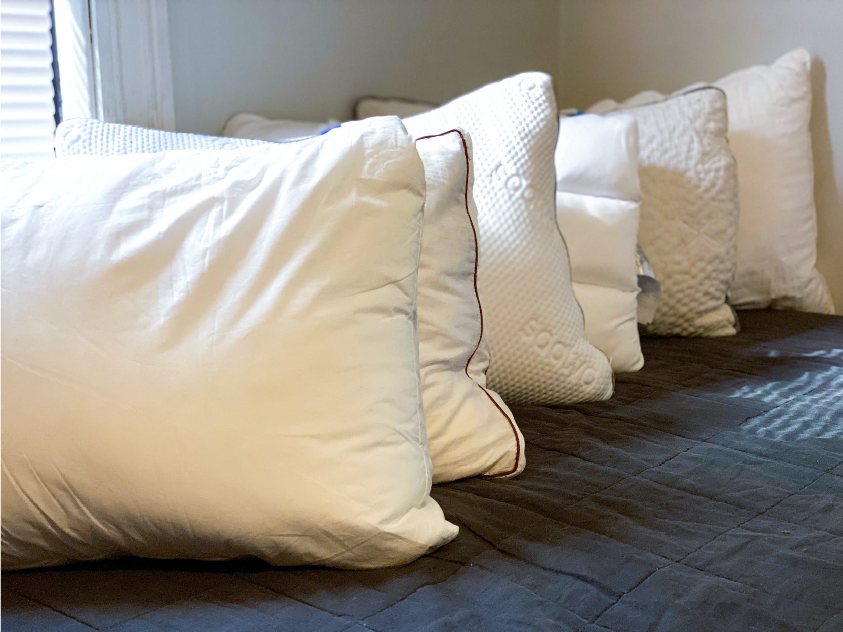 best pillows 4x3 featuring four pillows lined up neatly on a bed