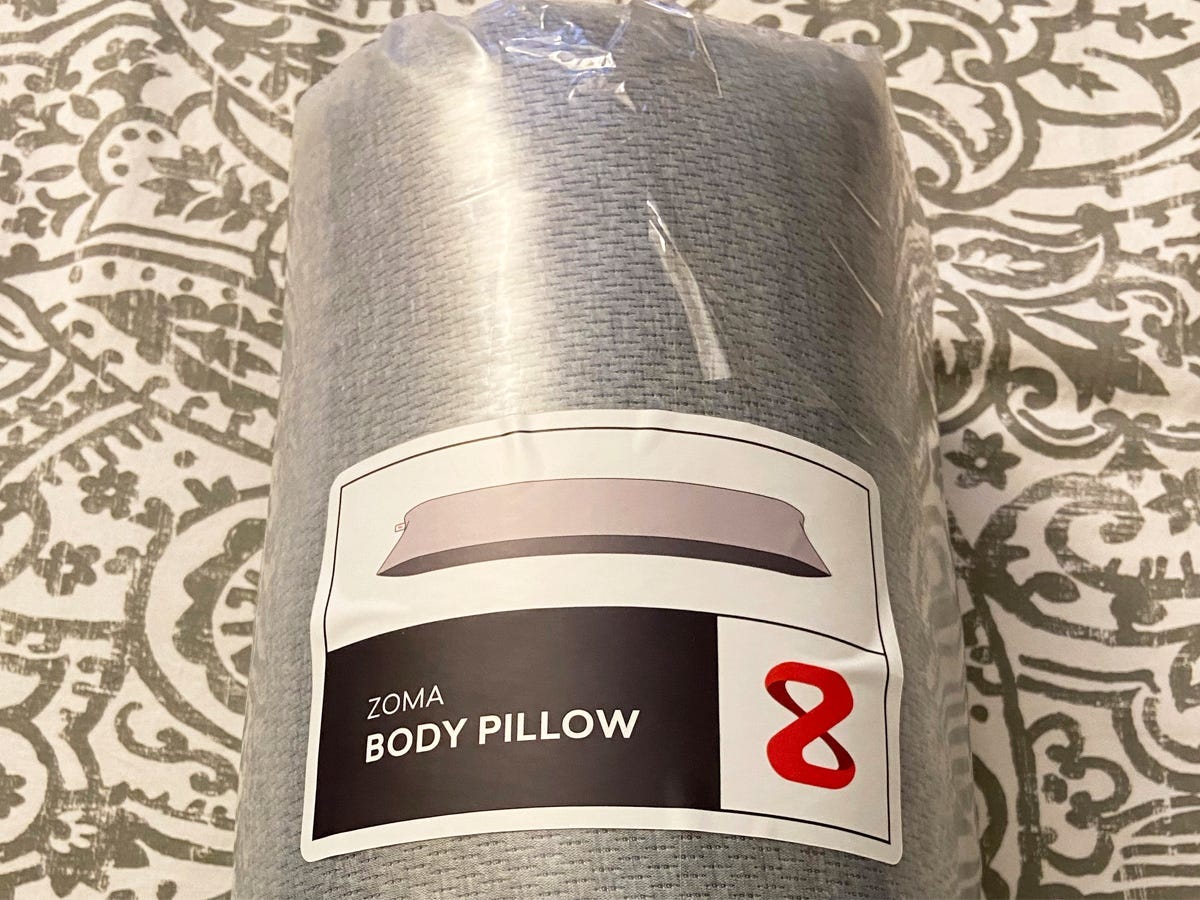 Best body pillow 2021 Zoma featuring the Zoma pillow on a bed in its original packaging