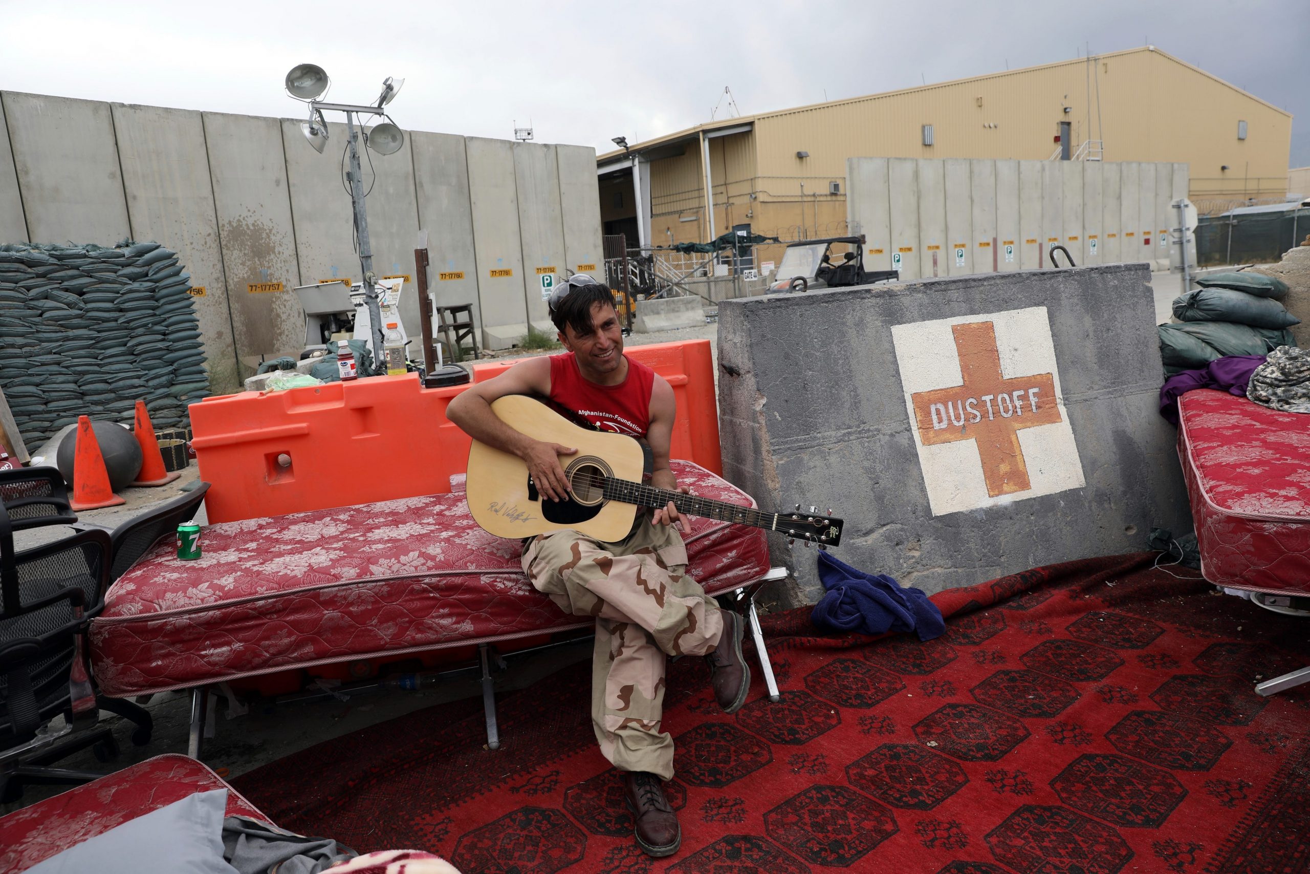 An Afghan soldier plays a guitar that was left behind after the American military departed Bagram
