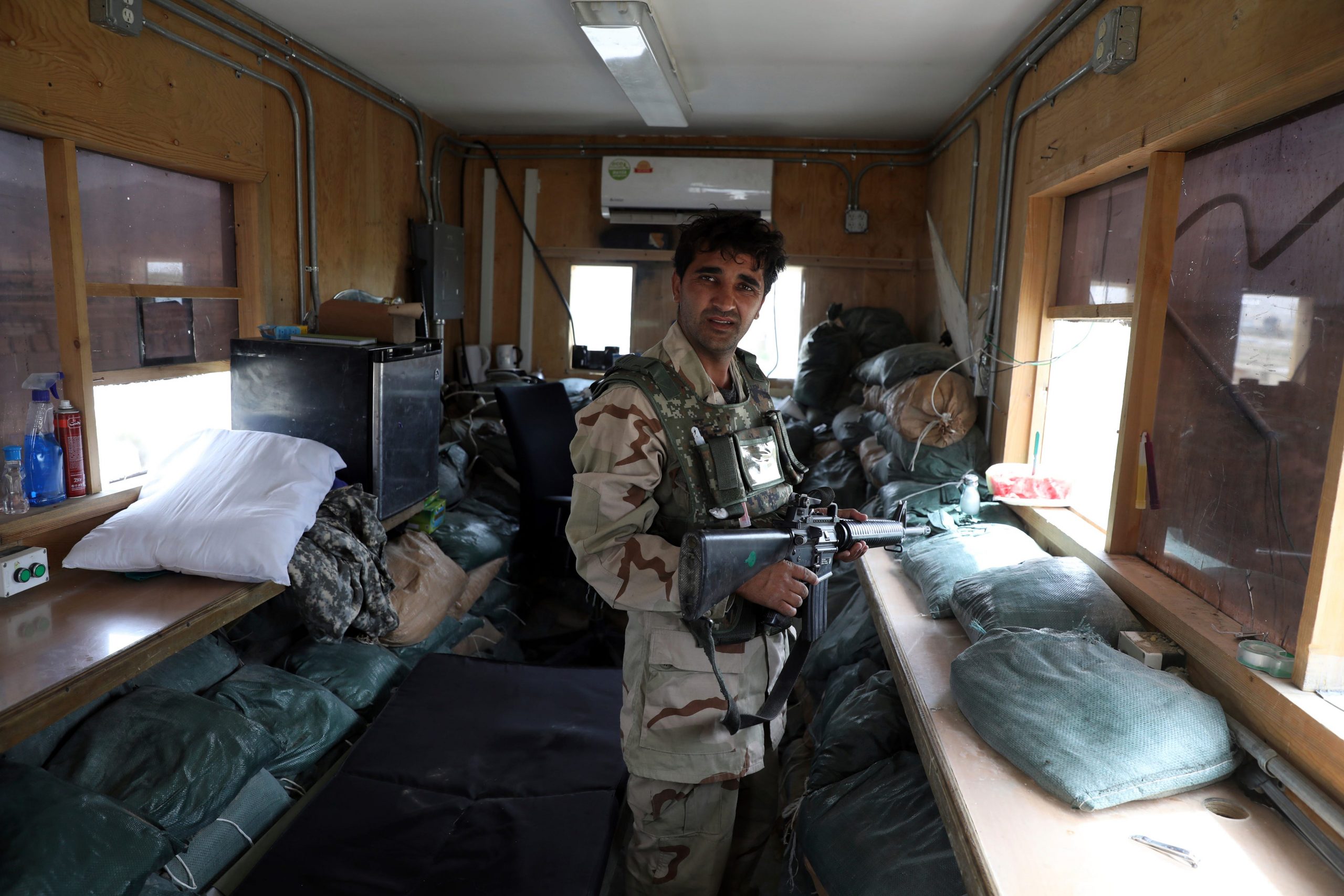 An Afghan security force member standing amid things left behind by the US forces that departed Bagram